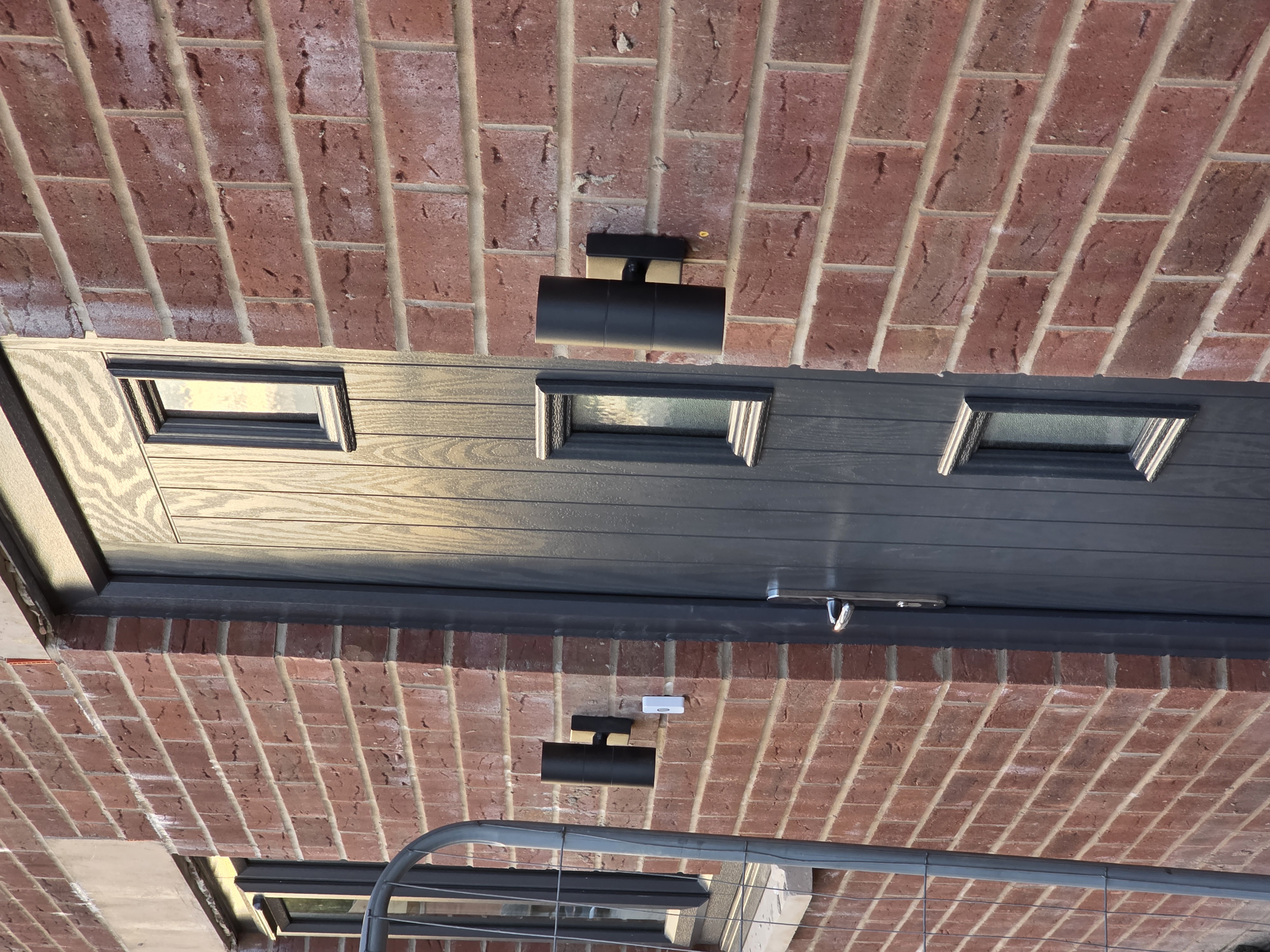 Black up/down entrance wall lights fitted either side of a front door